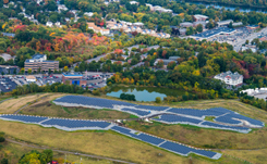 Daytime aerial view of a solar farm on a brownfield site at the edge of Lowell, Massachusetts.